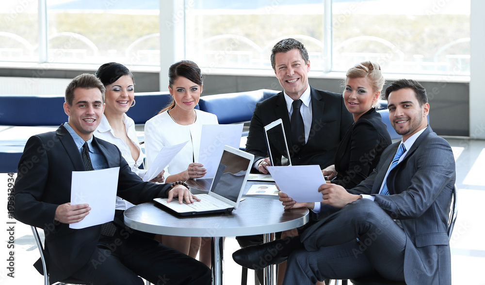 group of business people with documents sitting at a table in the lobby of the Bank. group of business people with documents sitting at a table in the lobby of the Bank.