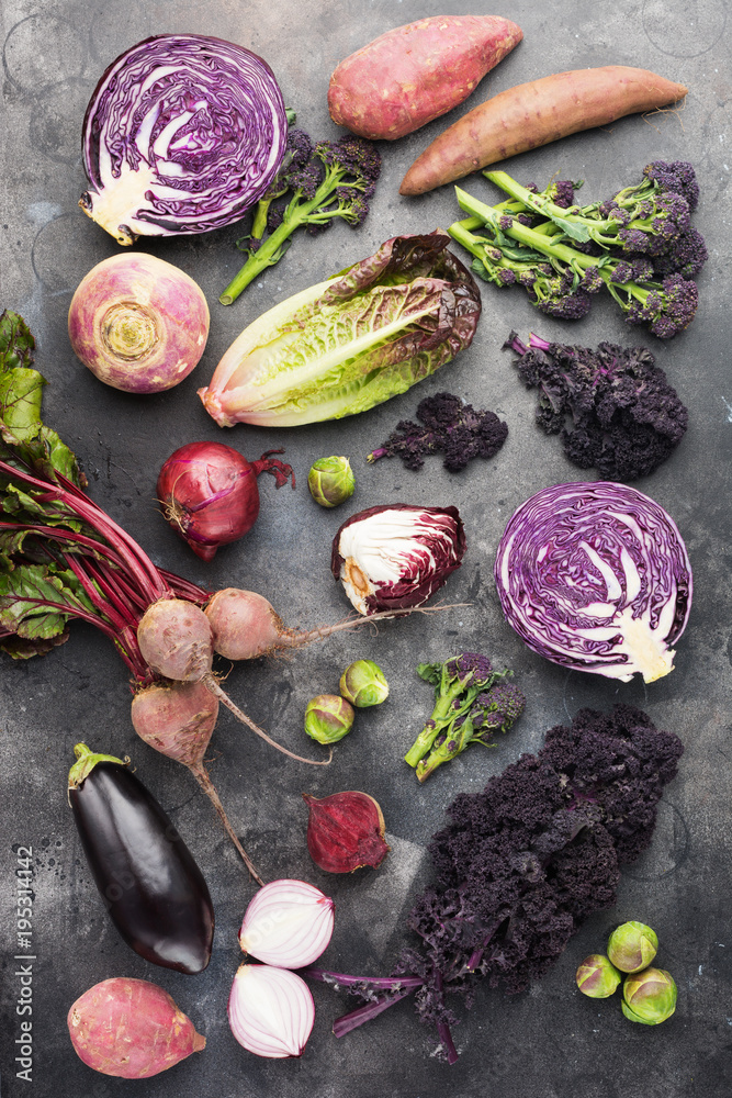Vegetables background with purple, green and dark red colours, cabbage kale sprouts sweet potato onions broccoli beetroot, top view, vertical, dark grey background, selective focus Vegetables background with purple, green and dark red colours, cabbage kale sprouts sweet potato onions broccoli beetroot, top view, vertical, dark grey background, selective focus