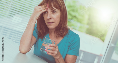 Mature woman having a headache, light effect