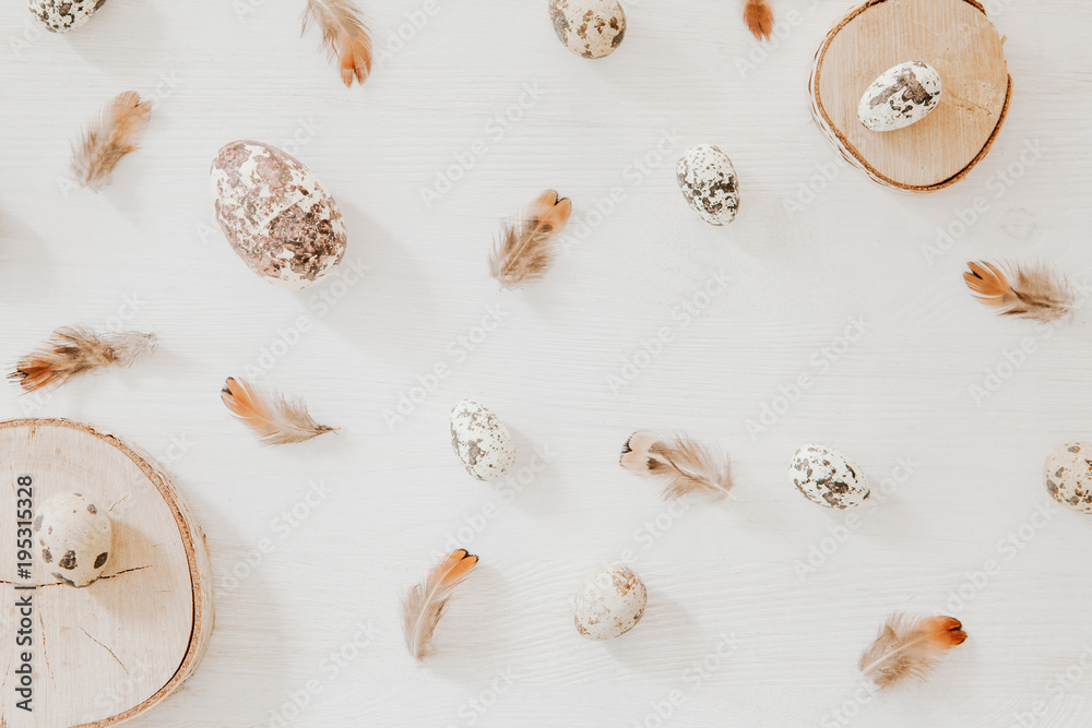 Easter, spring concept with wooden blocks, eggs and feathers. Flat lay, top view. Easter, spring concept with wooden blocks, eggs and feathers. Flat lay, top view.