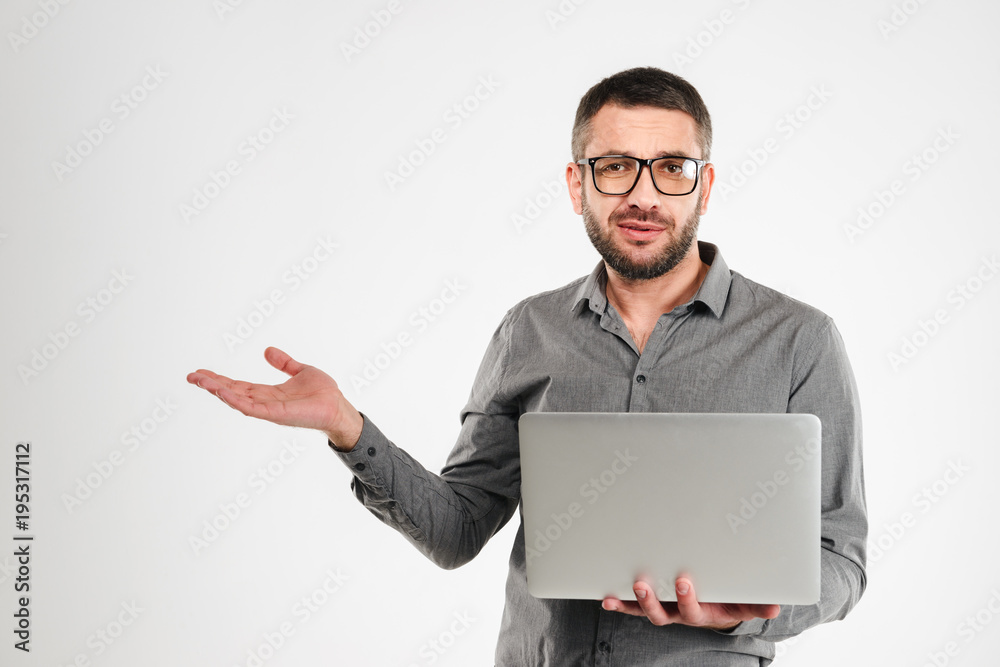 Confused businessman using laptop computer.