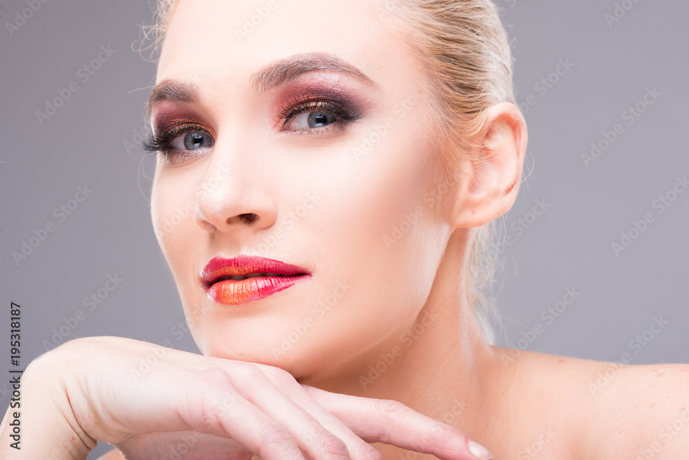 Model posing with hand on chin wearing professional make-up. Model posing with hand on chin wearing professional make-up.