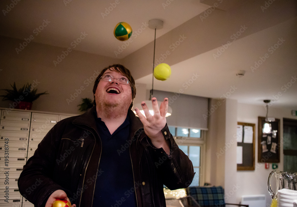 A man juggling in his house with three balls Stock Photo | Adobe Stock