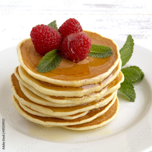 American pancakes with berries on a light background.