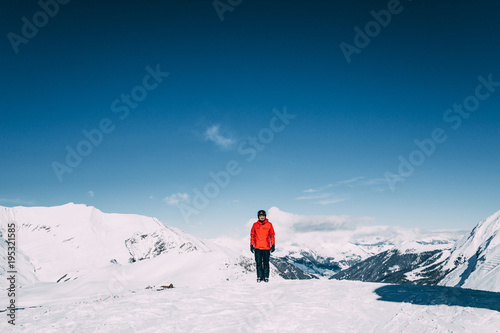 young man smiling at camera while standing in snow-covered mountains in mayrhofen ski area, austria