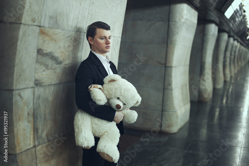 Sad Man holds a toy in the hands of a bear. photo