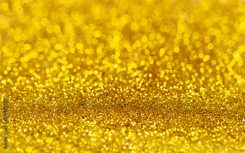 Golden beautiful blurred bokeh background with copy space. Holiday texture. Wallpaper. Glitter light spots on golden background, defocused