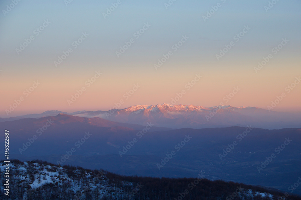 mountains and valley andscape in winter at sunset