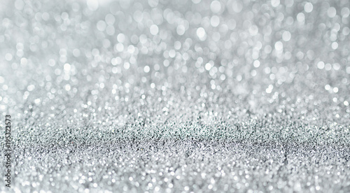 Sparkling festive background. Melting macro snowflakes close up with bokeh at the background. Image with small depth of field. Silver defocused glitter background with copy space.