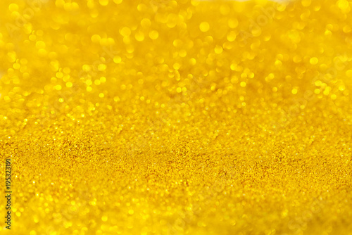 Golden beautiful blurred bokeh background with copy space. Holiday texture. Wallpaper. Glitter light spots on golden background, defocused