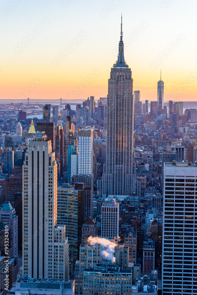 Naklejka premium Nowy Jork - USA. Widok na panoramę centrum Dolnego Manhattanu ze słynnym Empire State Building i One World Center oraz drapacze chmur o zachodzie słońca.