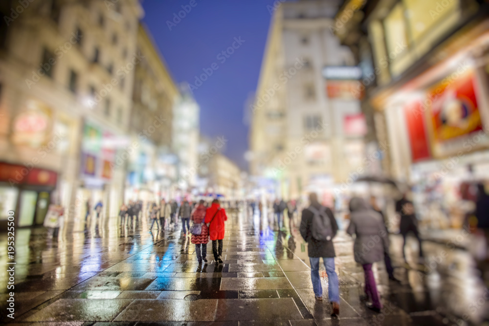 people walking on rainy night streets in vienna
