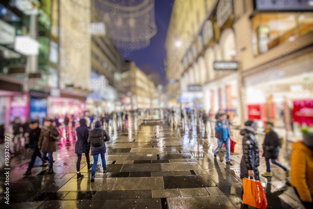 people walking on rainy night streets in vienna