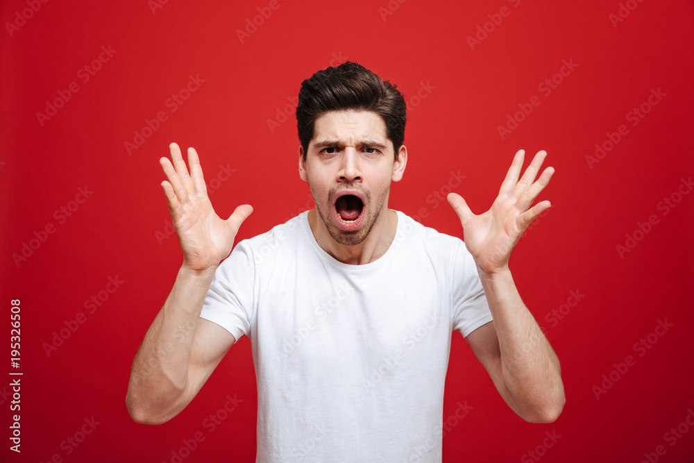 Portrait of a shocked young man in white t-shirt Portrait of a shocked young man in white t-shirt