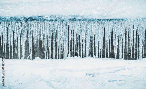 Row of big frosty icicles in nature.Row of big frosty icicles in nature. Icicles Background