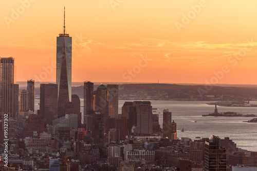 New York City - USA. View to Lower Manhattan downtown skyline with famous Empire State Building and One World Center and skyscrapers at sunset.