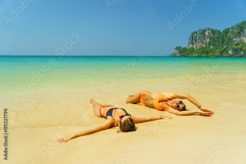 Fototapeta Naklejka Na Ścianę i Meble -  Two women resting at the  tropical Thailand Railay beach