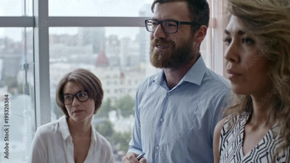 Tilt up shot of colleagues talking to each other in friendly manner when discussing project details Tilt up shot of colleagues talking to each other in friendly manner when discussing project details