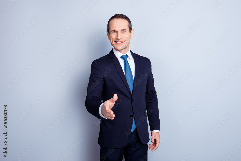 Cheerful financier, positive economist, corporate, responsible politic man in formalwear with tie offering hand for shaking, having a deal, standing over gray background Cheerful financier, positive economist, corporate, responsible politic man in formalwear with tie offering hand for shaking, having a deal, standing over gray background