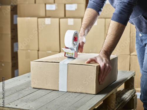 Worker closing package with package tape