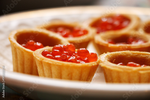 Red caviar in a waffle basket on a plate
