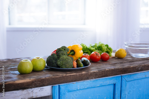 Natural vitamins. Useful necessary fresh fruits and vegetables placed in plate and put on surface