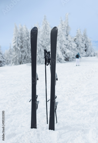 Skis and sticks stuck in snow on mountain peak