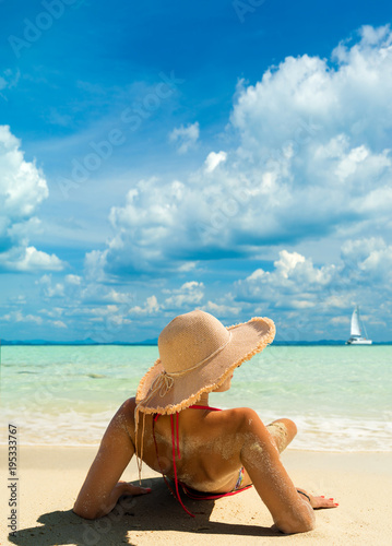 Beach suntan vacation bikini woman lying down tanning under tropical sun in Caribbean.