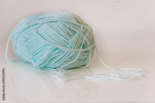 Closeup of colored yarn for knitting, skeins in green on white background, texture. Hobby concept.