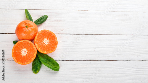 Fresh mandarin with leaves. Fruits. On a wooden background. Top view. Copy space.