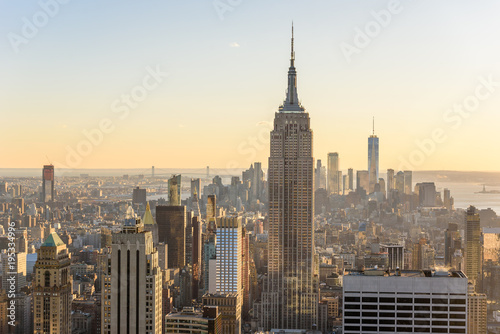 New York City - USA. View to Lower Manhattan downtown skyline with famous Empire State Building and skyscrapers at sunset. © Simon Dannhauer