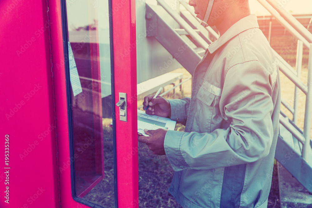 safety officer working on checking Fire extinguisher at outdoor plant.