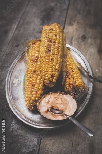 grilled corn with cocktailsauce on a wooden background photo