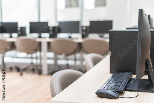 Computer lab blur background with pc desktop computer machine in blurry school class or office desk workspace © Chinnapong