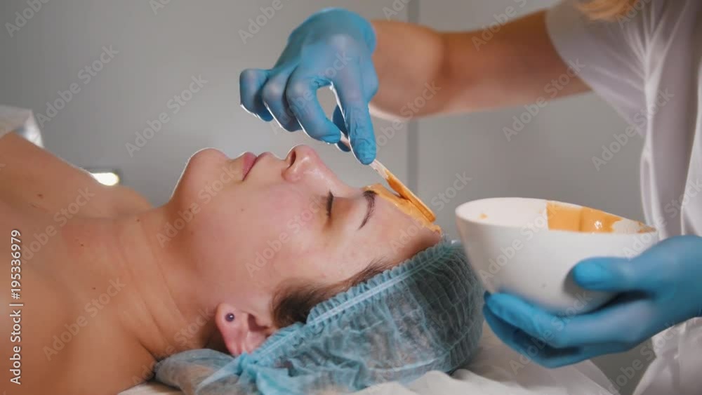 Woman doctor performes cosmetic procedure - mask facial massage at spa salon skincare Woman doctor performes cosmetic procedure - mask facial massage at spa salon skincare