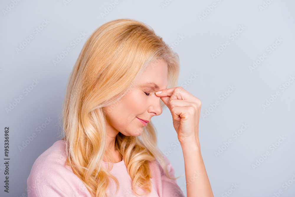 Side half-faced view portrait of sad unhappy tired frustrated upset stressful nervous with negative emotions touching nose-bridge closed eyes isolated on gray background copy-space Side half-faced view portrait of sad unhappy tired frustrated upset stressful nervous with negative emotions touching nose-bridge closed eyes isolated on gray background copy-space