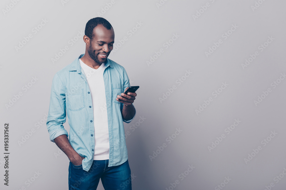 Portrait with copy space, empty place of cheerful guy in jeans, shirt  having smart phone, holding arm in pocket of pants, texting sms, checking  email, searching contact, using wifi, 5G internet Stock