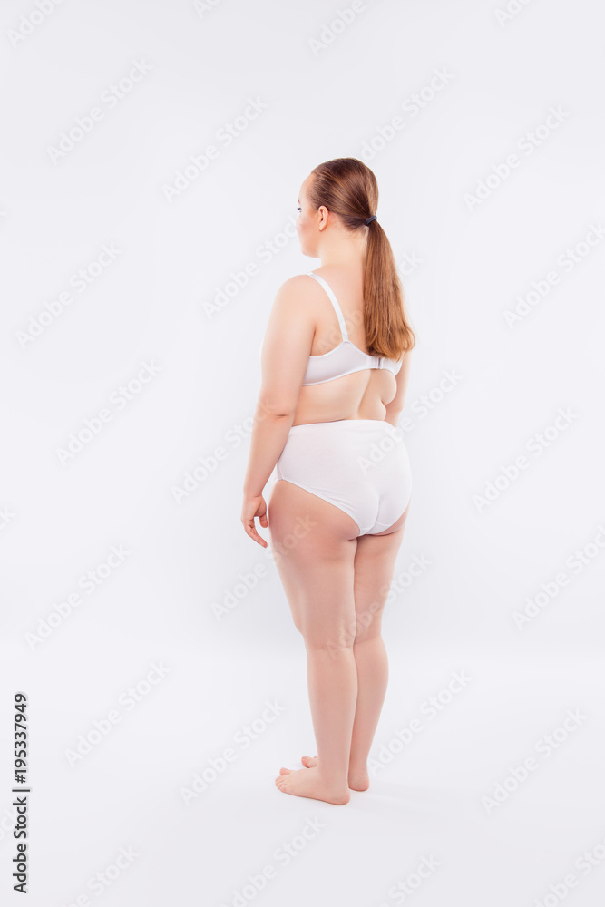 Rear view of young woman standing in underwear Photos | Adobe Stock