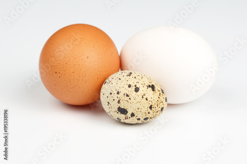 chicken and quail eggs close on a white background