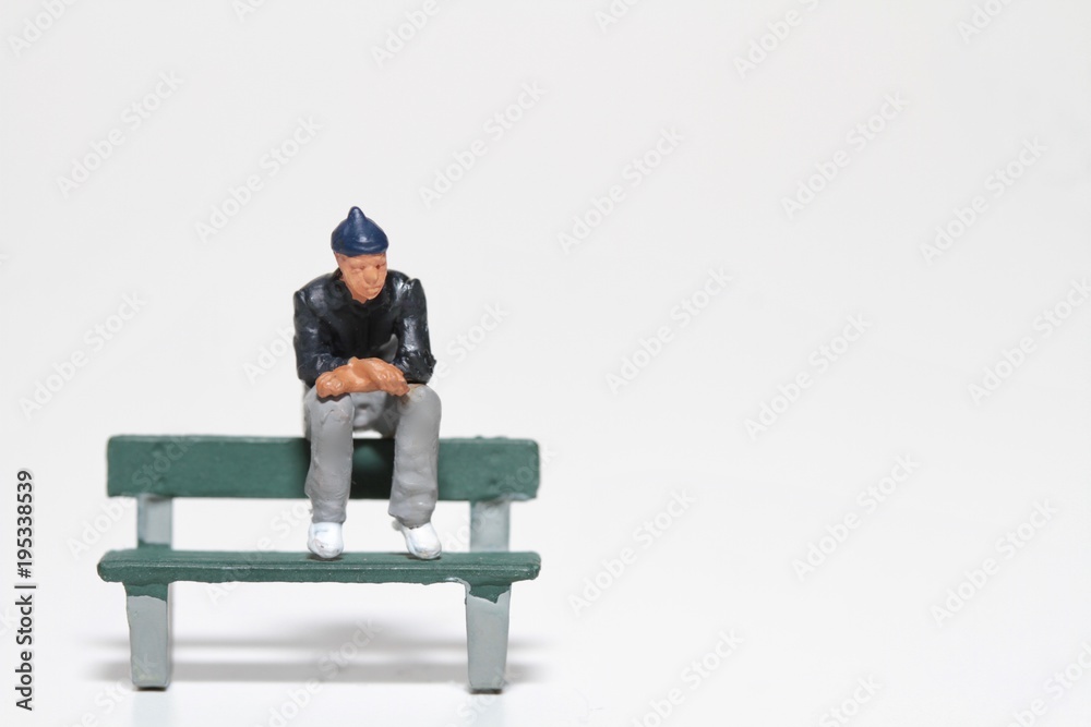 miniatura di ragazzo depresso seduto sopra una panchina del parco