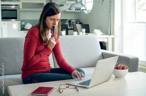 Schilderij op canvas junge Frau arbeitet zu Hause und sitzt nachdenklich am Laptop