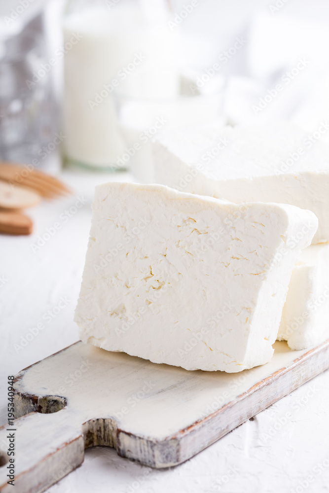 Fresh cottage cheese on rustic white wooden board