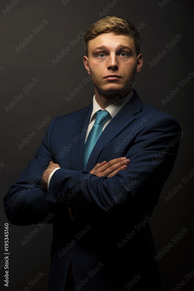 Businessman in suit over dark background, crossed arms, portrait. Businessman in suit over dark background, crossed arms, portrait.