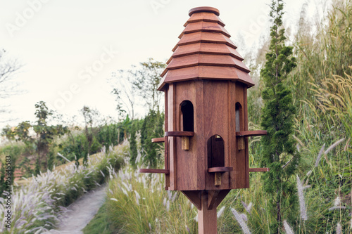 A beautiful wooden bird house with garden in background © AON