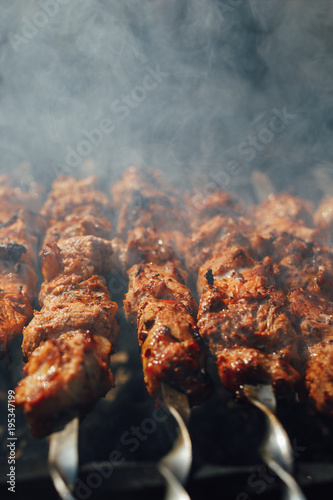 grilled barbecue meat on skewers with smoke