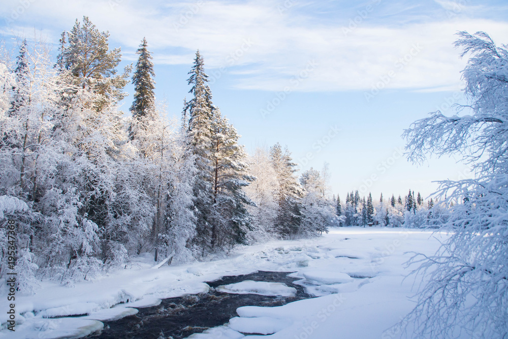 Obraz premium Half frozen Raudanjoki peat river on a sunny winter day, Vaattunki, Finland.