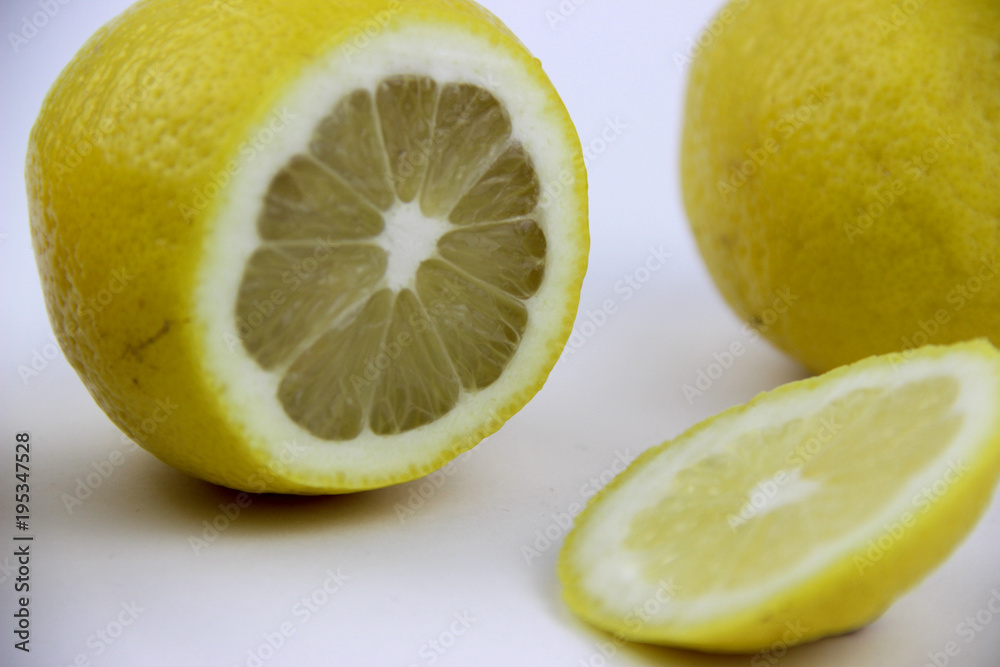 bright, yellow lemons. whole and sliced on a plate. bright, yellow lemons. whole and sliced on a plate.