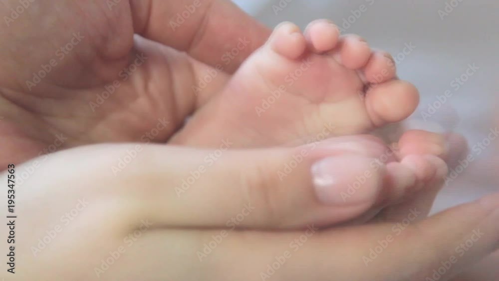 Baby Feet In Mother Hands. Newborn Baby's Feet On Female Hands Closeup Baby Feet In Mother Hands. Newborn Baby's Feet On Female Hands Closeup