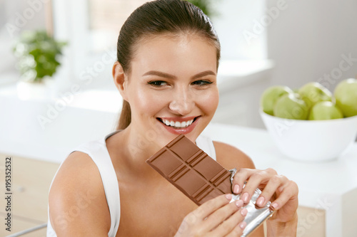 Chocolate. Happy Woman Biting Chocolate Bar.