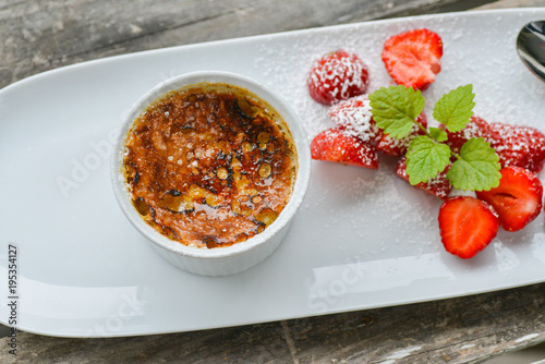 Fotografie Crème brûlée with white chocolate served with strawberries